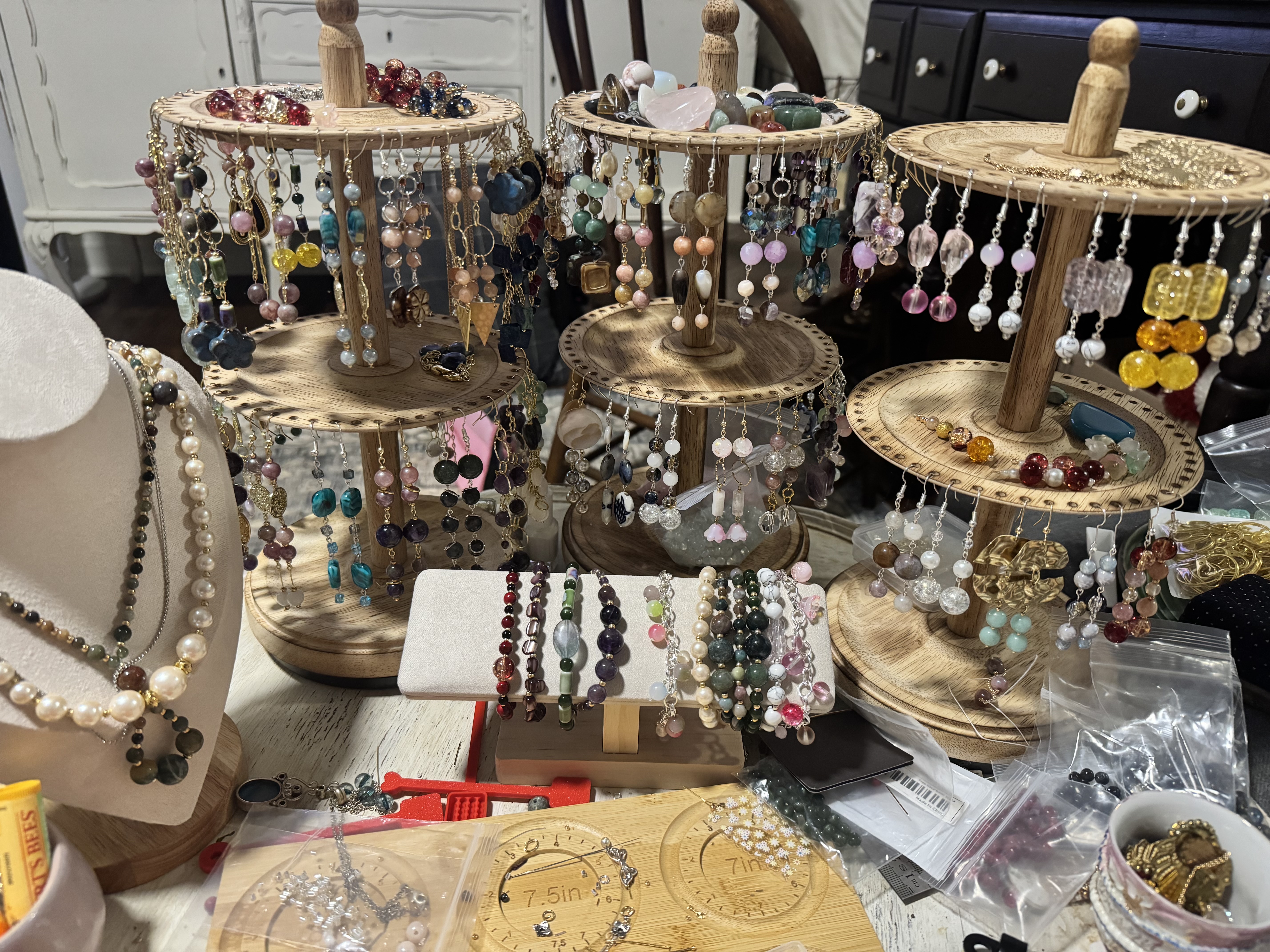 Colorful beaded earrings, bracelets, and necklaces displayed on wooden stands