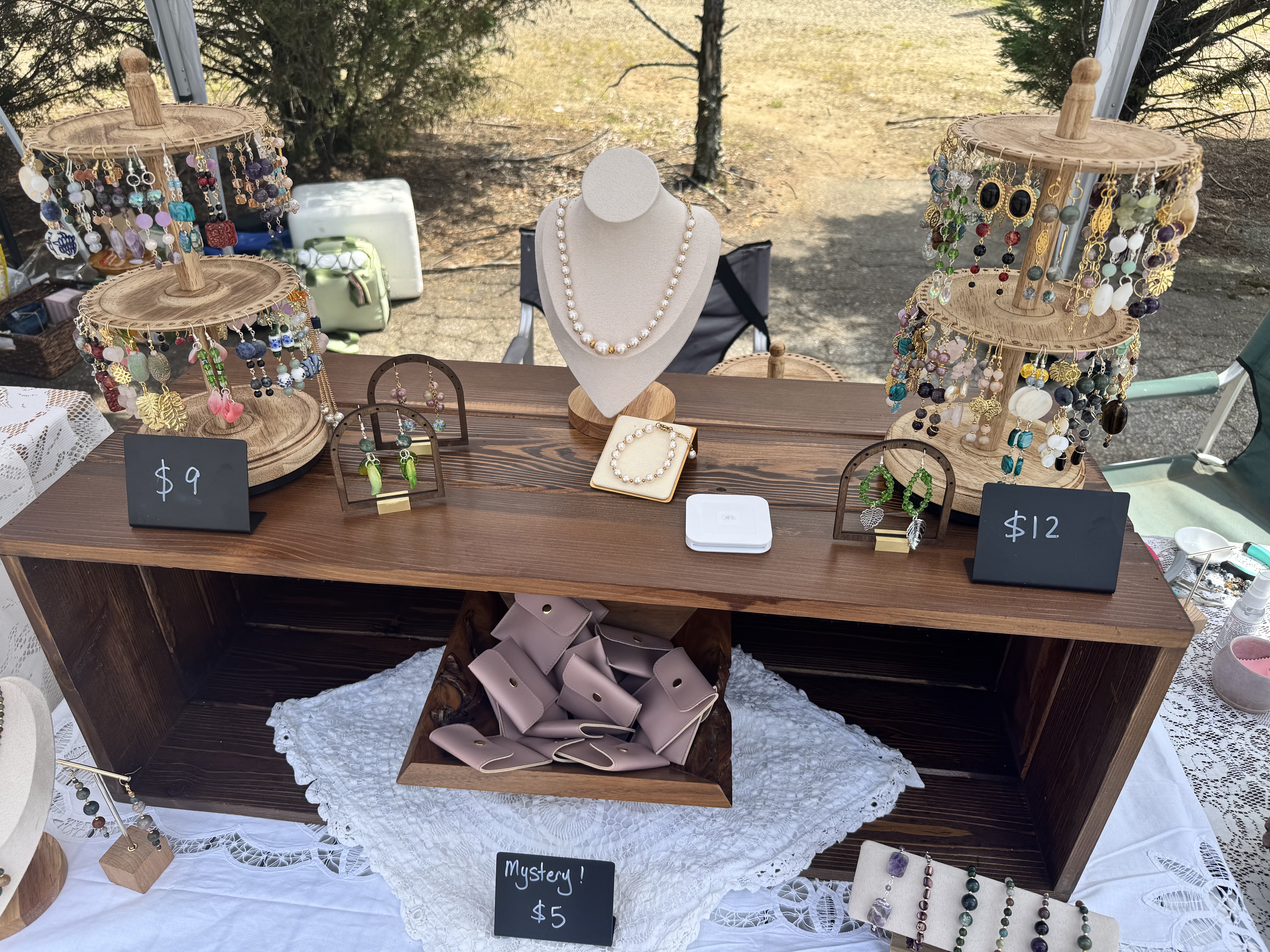 Top view of market table with pearl necklace on bust and earring towers